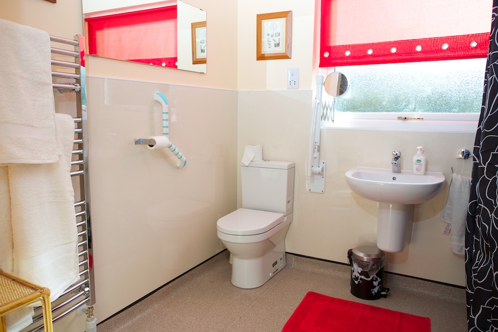 Photo of accessible WC with grab rails and wash basin in Cosaig self-catering Innerleithen