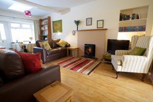 Photo of living room in holiday house showing sofas with cushions, bookshelves and fireplace Cosaig Self-Catering Innerleithen